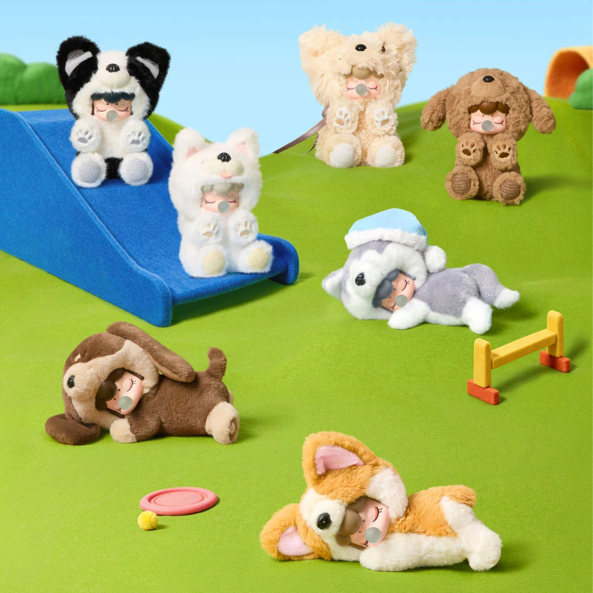 Rolife Nanci Puppy Club collection of six dog-themed plush dolls arranged on a green miniature playground, with Dachshund, Corgi, Husky, Border Collie, Teddy and Samoyed designs.