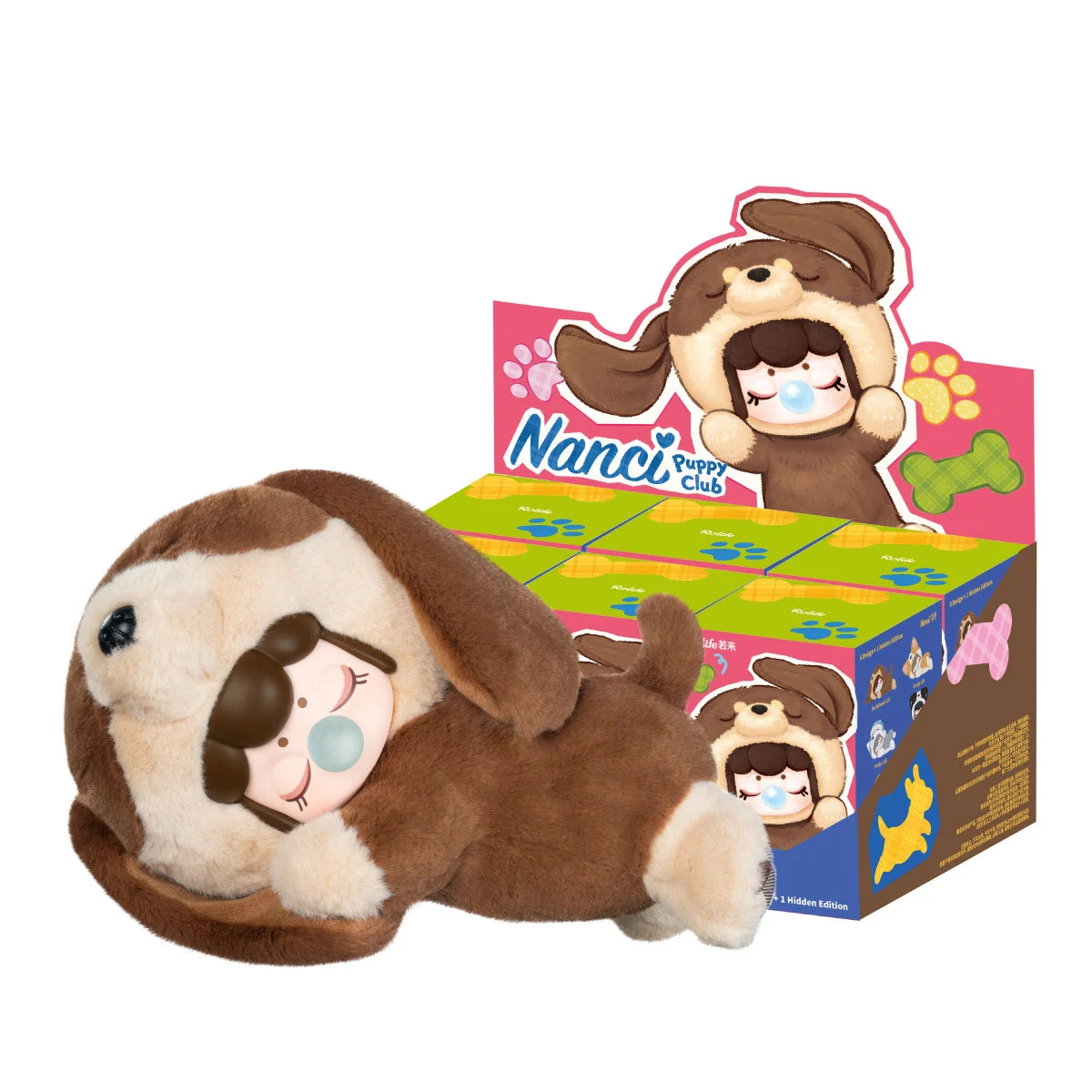 Rolife Nanci Puppy Club MNFXX brown-and-cream Dachshund plush doll lying beside colorful blind-box display packaging on a white background, with floppy ears, a sleeping Nanci face and blue bubble.