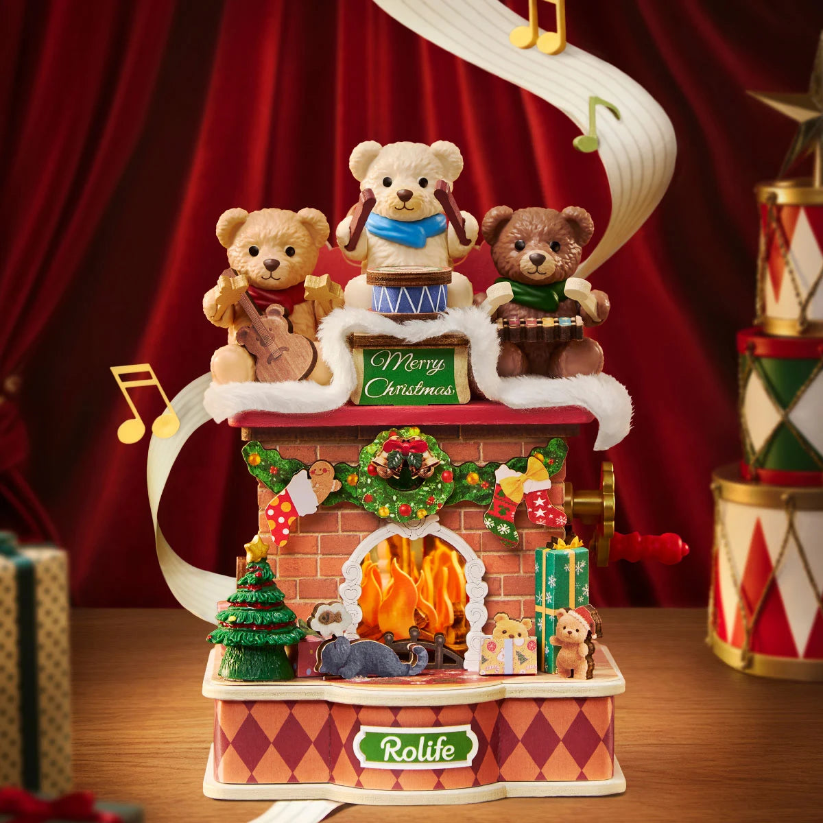 Rolife Christmas musical brick fireplace model with three teddy bears playing guitar, drum and xylophone on a snowy roof, lit fireplace, miniature tree and gifts, red curtain backdrop.