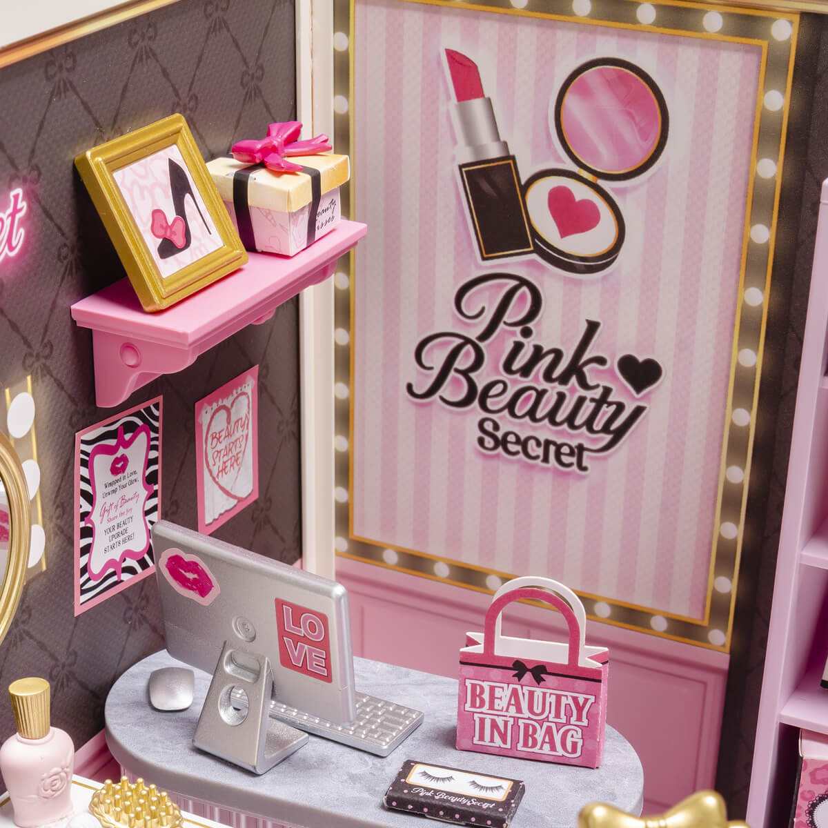 Close-up of Pink Beauty Secret wall poster, shelf, laptop, and beauty bag