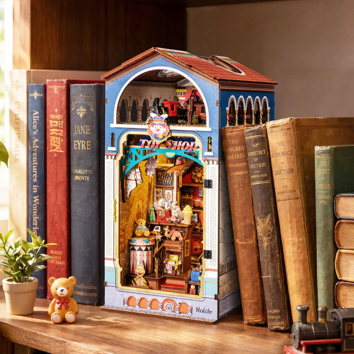 Rolife Treasure Toy Shop DIY Book Nook displayed between books on a shelf