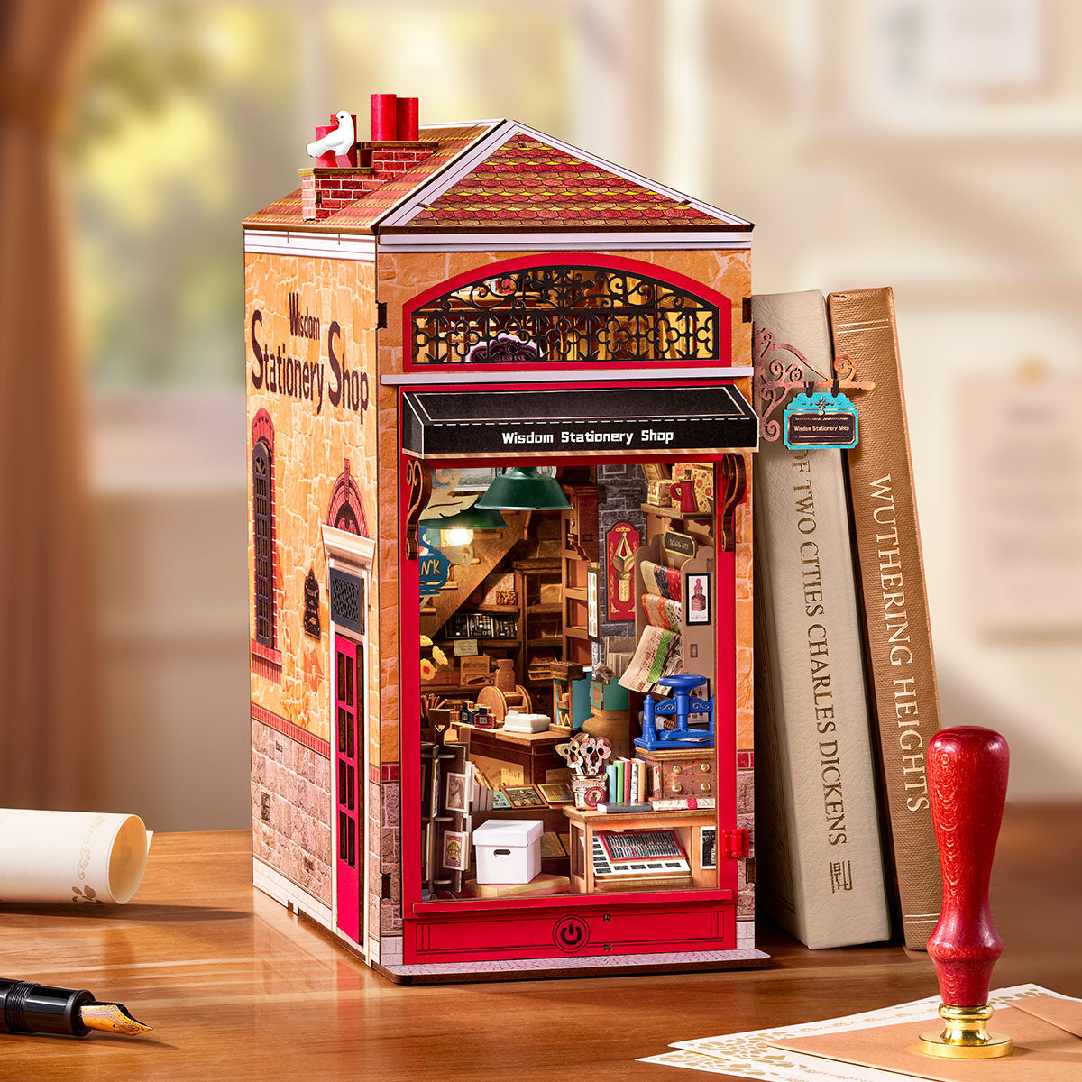 Rolife Wisdom Stationery Shop DIY Book Nook displayed on a desk beside books