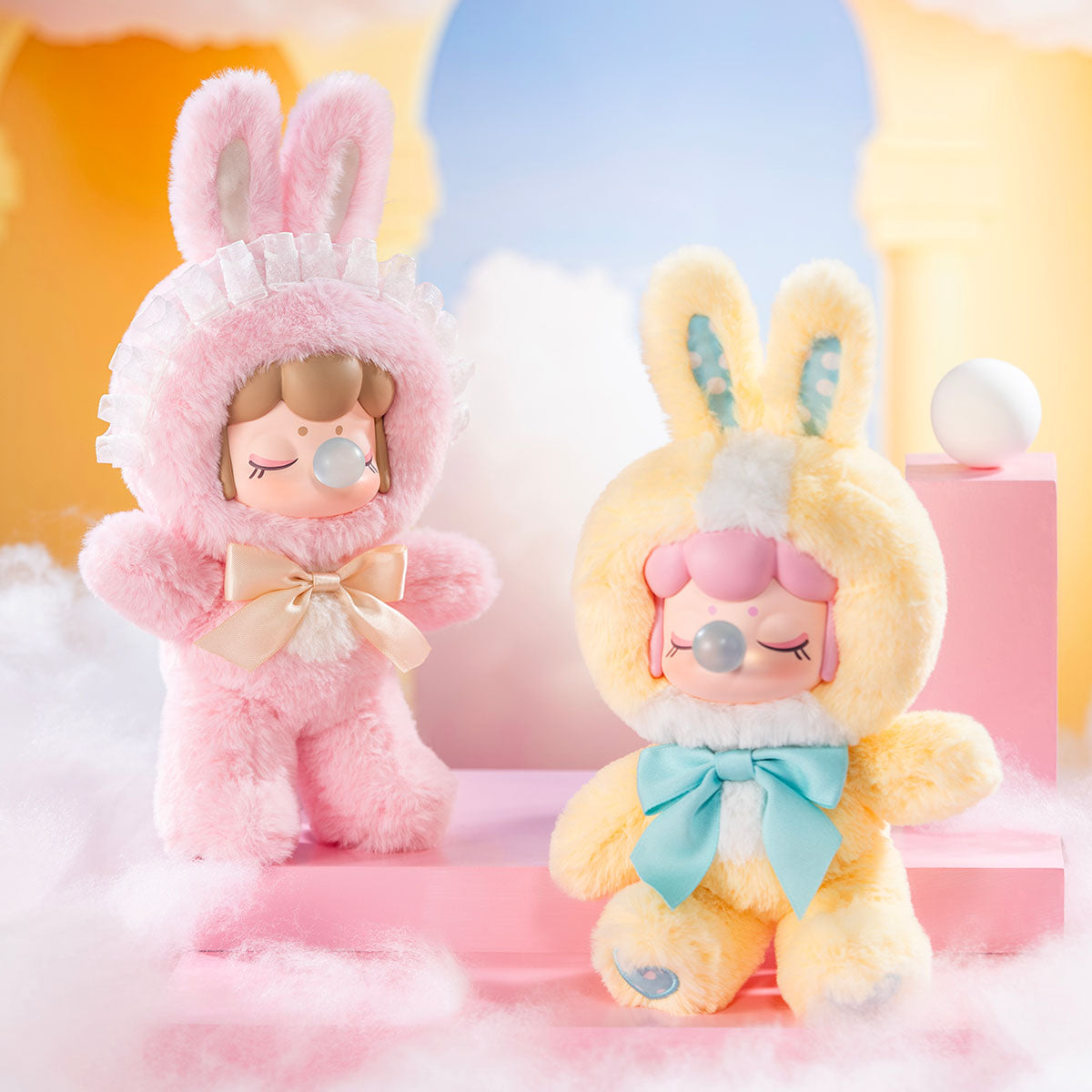 Nanci's Shining Bunny MNBXX pink and yellow plush dolls in a pastel display scene