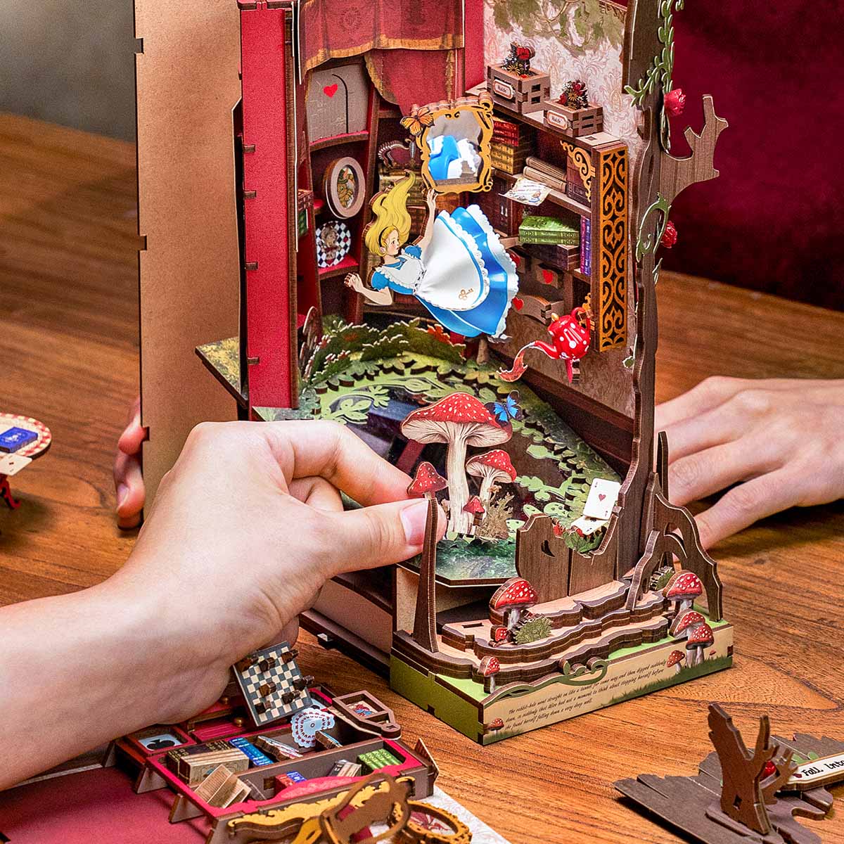 Hands assembling the Fall into Wonder TGB12 book nook scene