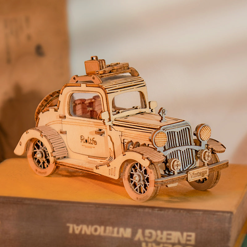 Rolife Vintage Car TG504 wooden puzzle displayed on stacked books