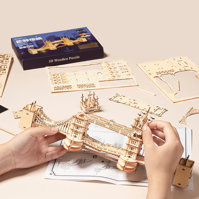 Hands building the Rolife Tower Bridge TG412 with the box and instruction sheet